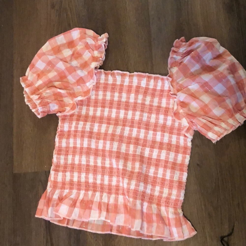 A pink and white checkered puff sleeve shirt